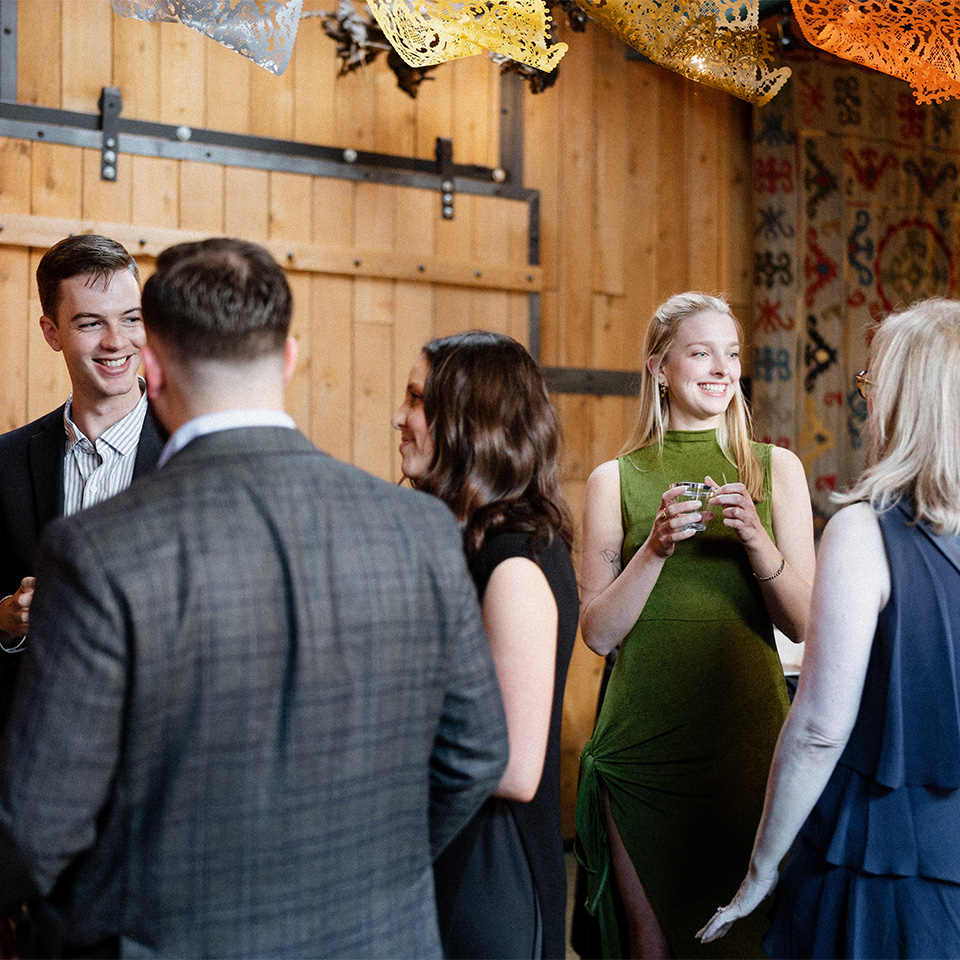 Group of people mingling and drinking wine at a McPherson Cellars event